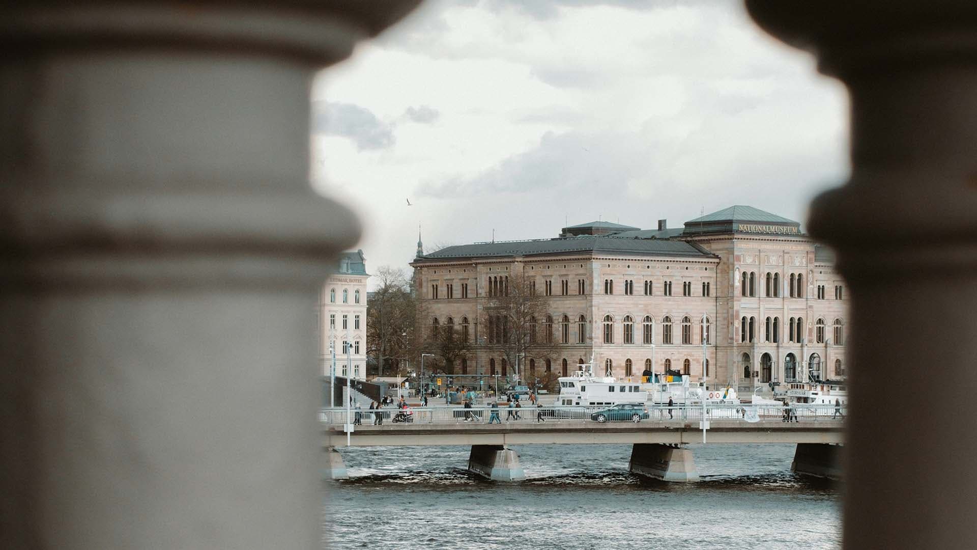 Historic building by the waterfront in central Stockholm, viewed between two columns.